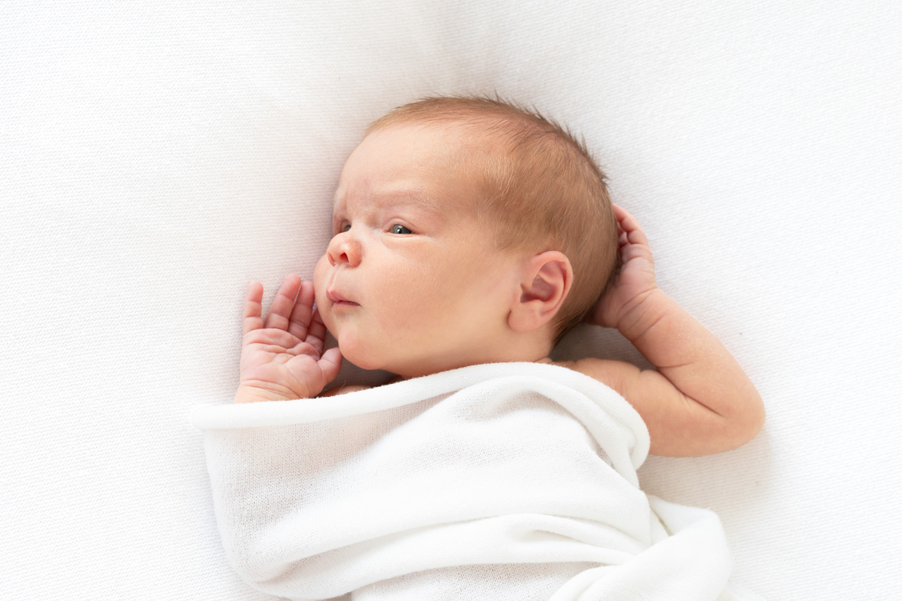 baby laying on bed for a newborn photo session